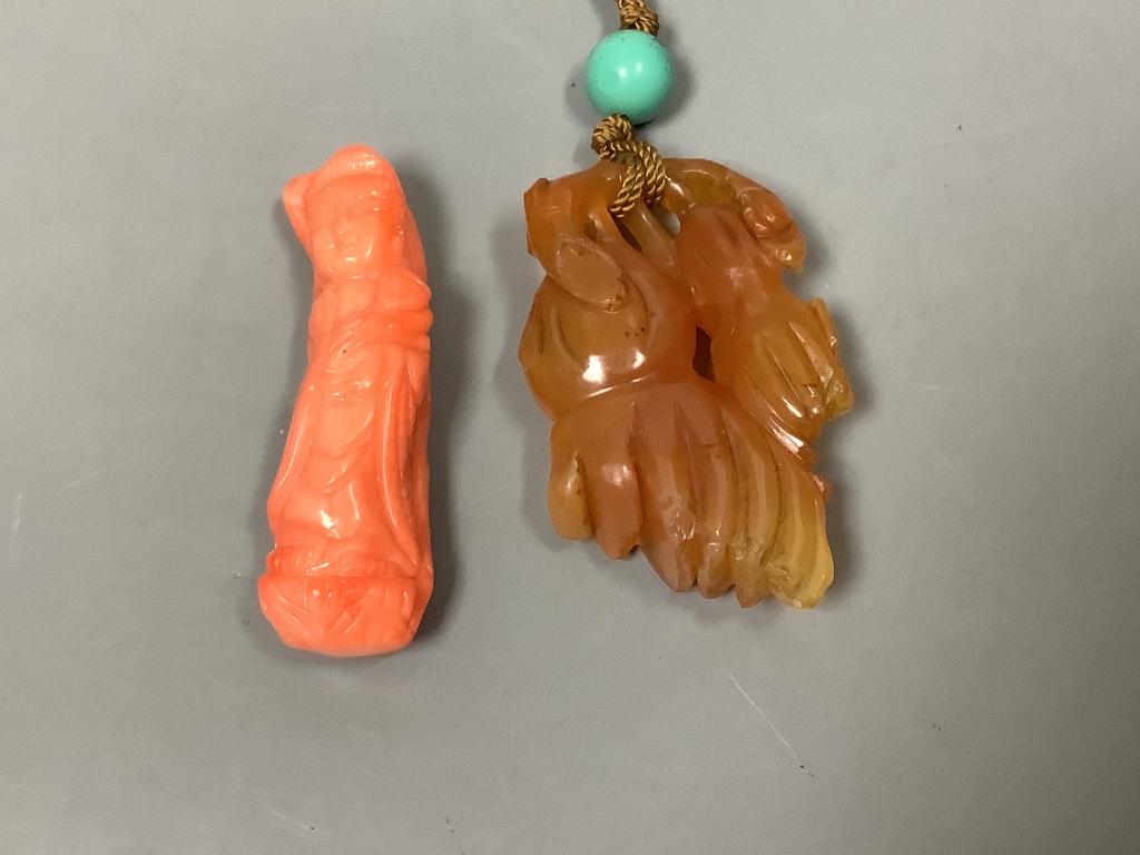 A Chinese carved hardstone pendant, a carved coral Guanyin, an engraved nut pendant, and a lacquered tray